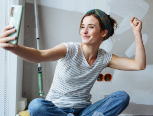 Jonge vrouw neemt een selfie tijdens het klussen