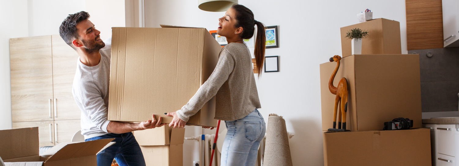 Man en vrouw tillen de verhuisdoos samen op