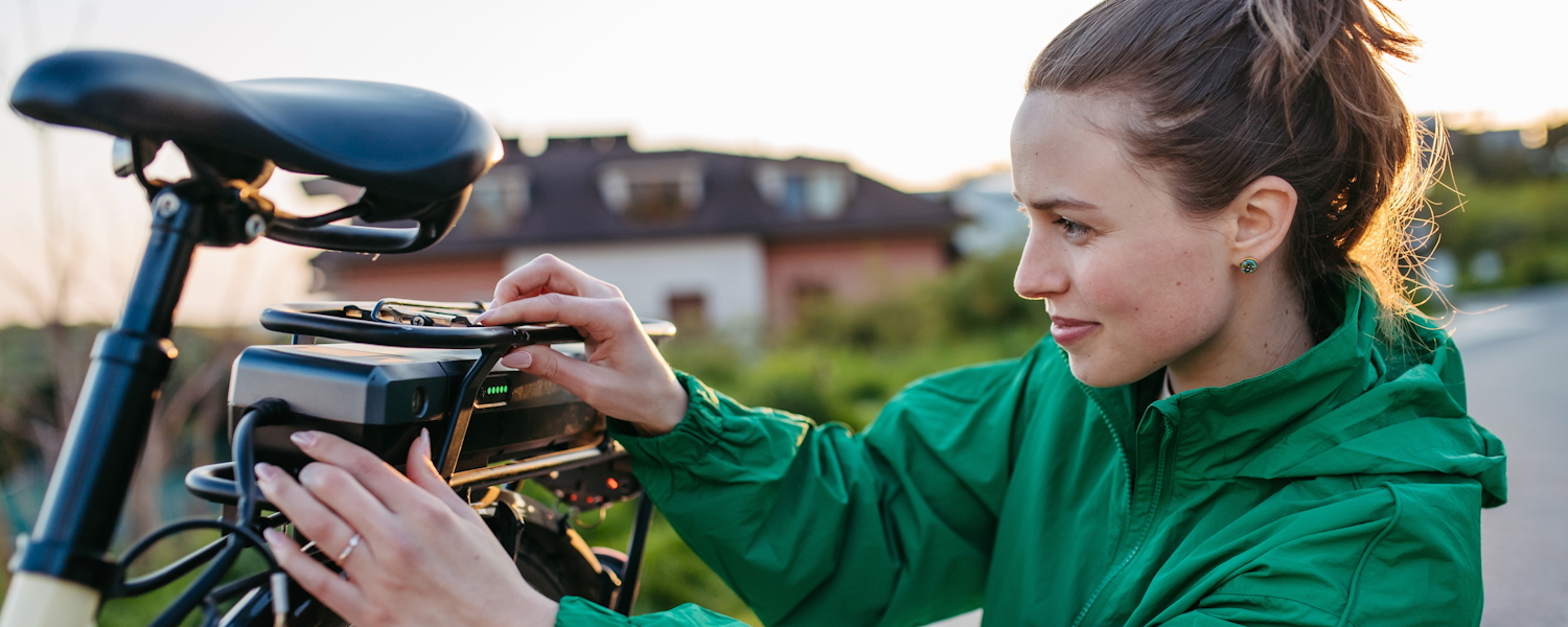 Vrouw bezig met accu van haar e-bike