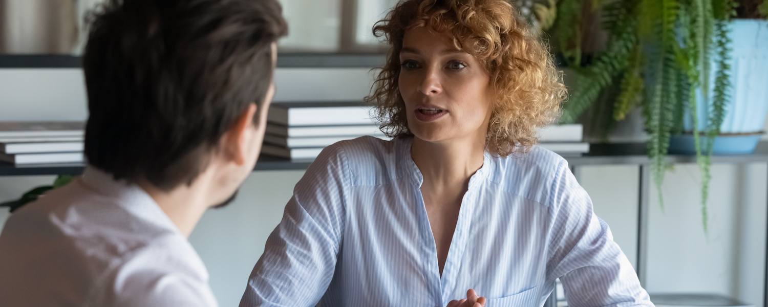 Vrouw in gesprek met man in kantoorsetting