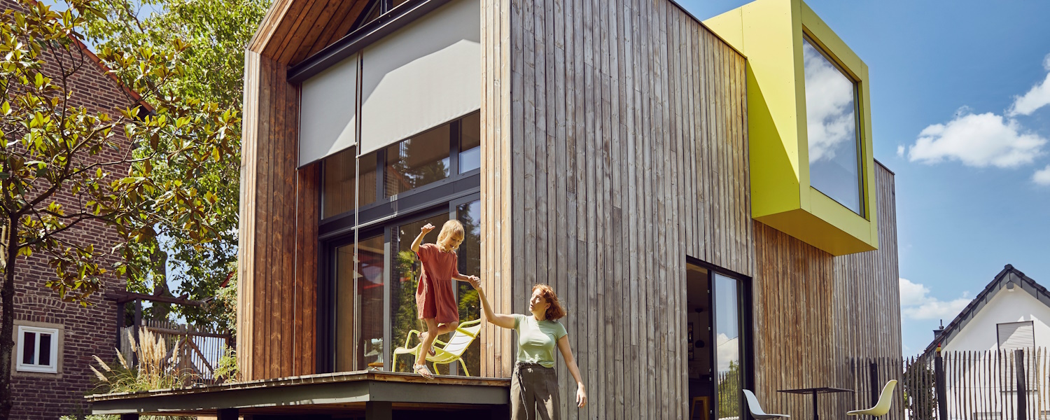 verduurzamen tiny house met terras en moeder met kind dat bijna van het terras valt.